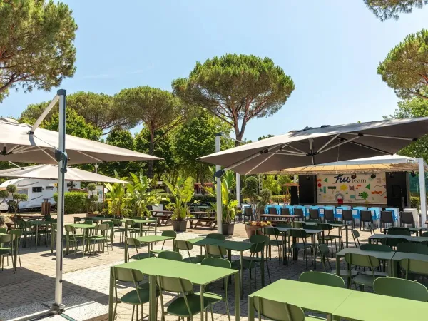 Terrasse avec scène au camping Roan hu I Pini village.